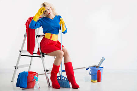 Tired pretty housewife in superwoman costumeの写真素材
