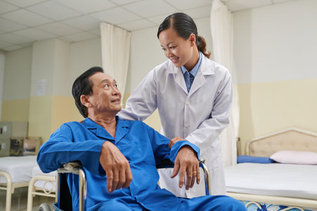Young nurse comforting senior man in wheelchair