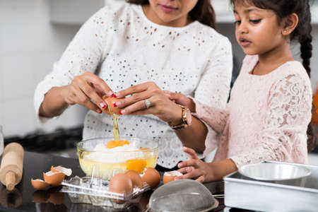 Cropped image of mother teaching her little daughter cookingの写真素材