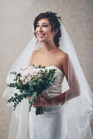 Charming smiling bride with bouquet of fresh flowersの写真素材