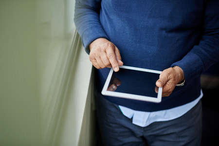 Close-up image of man using app on his tablet computerの写真素材