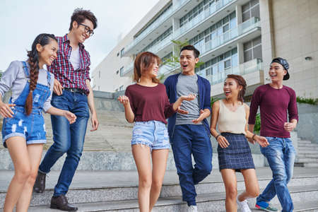 Group of Vietnamese young people walking and chatting outdoorsの写真素材
