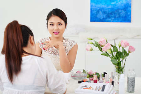 Beautiful Vietnamese girl enjoying manicure process in beauty salonの写真素材