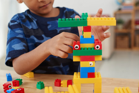 Boy playing with coloful cubes at the table