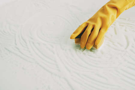 Hand of woman cleaning surface with sponge and foamの写真素材