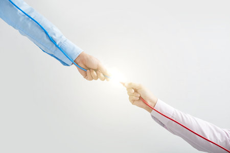 Two men connecting red and blue wiresの写真素材