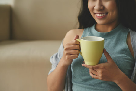 Cropped image of woman enjoying cup of coffeeの写真素材