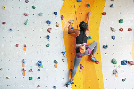 Back view of sportswoman climbing in the gymの写真素材