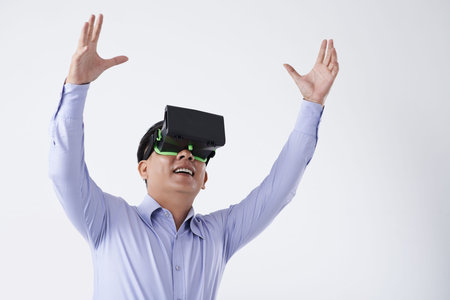 Asian businessman in VR goggles enjoying new technology