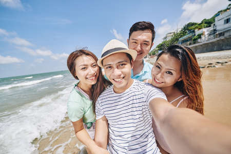 Asian smling young people taking selfie at the beachの写真素材