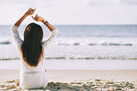 Rear view of young woman enjoying her time at beachの写真素材