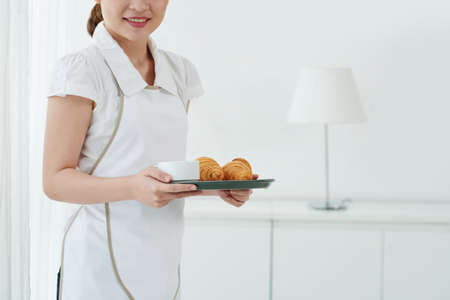 Maid bringing tea and croissants to the roomの写真素材