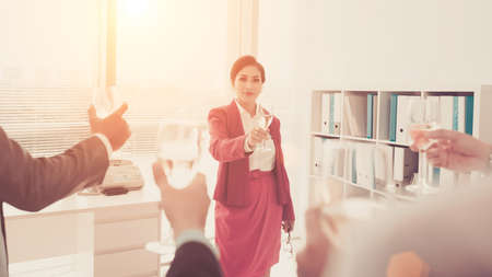 Pretty business executive and her employees celebrating successの写真素材