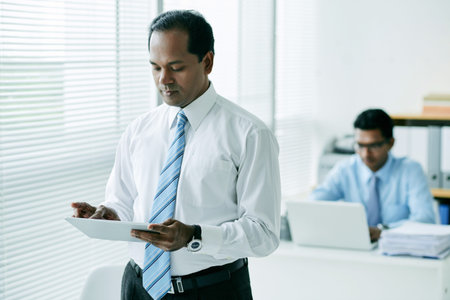 Indian entrepreneur using application on tablet computerの写真素材