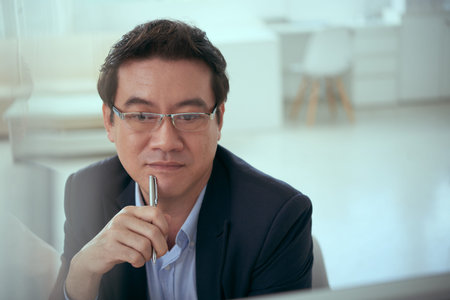 Portrait of Vietnamese business executive looking at monitorの写真素材