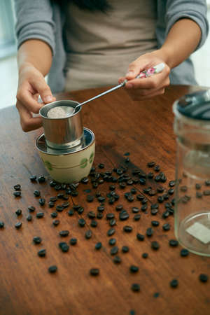 Hands of woman making coffee, selective focusの写真素材