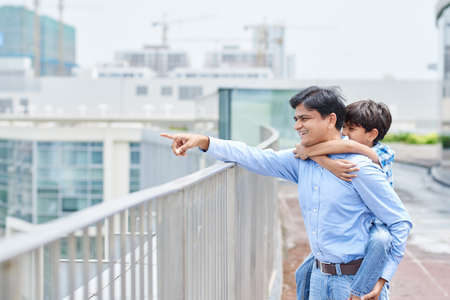 Indian father and son enjoying view from the bridgeの写真素材