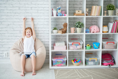 Happy girl excited after winning game on tabletの写真素材
