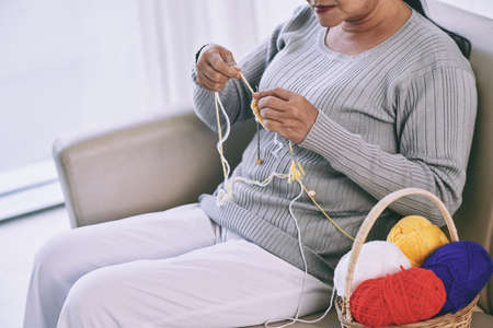 Cropped image of woman knitting at homeの写真素材