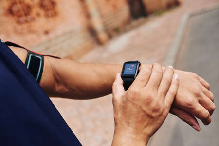 Cloe-up image of sportsman checking his pulse on smart watchの写真素材