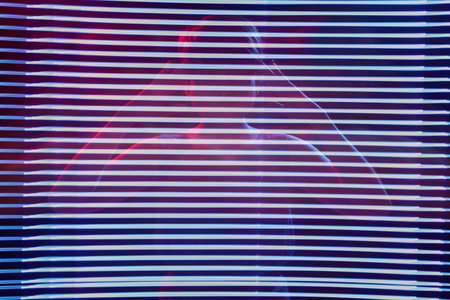Silhouette of business woman looking through blinds