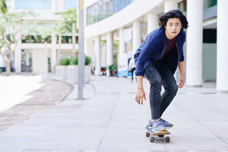 Vietnamese young guy skateboarding in the cityの写真素材