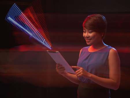 Smiling Asian woman using digital tablet to send information