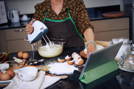 Cropped image of woman making cream for cake