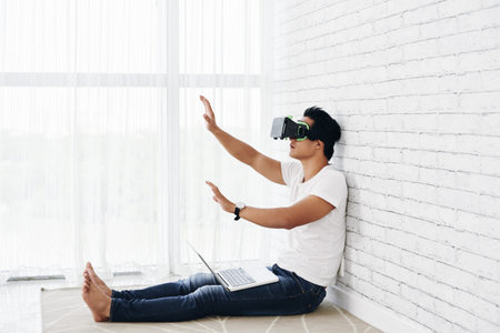 Young man in special glasses experiences virtual realityの写真素材