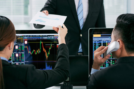 Businessman giving financial document to female coworkerの写真素材