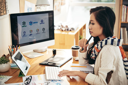 Concentrated Vietnamese designer working on project in her studioの写真素材