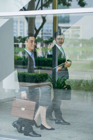 Asian coworkers going to business meeting in officeの写真素材