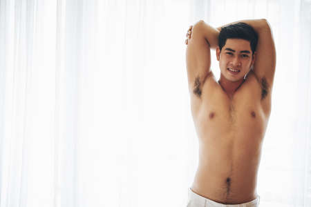 Handsome attractive man stretching and smiling at cameraの写真素材