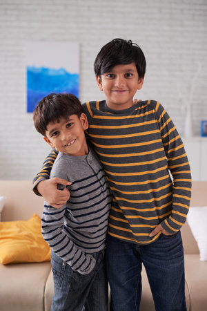 Portrait of two hugging Indian brothers looking at camera