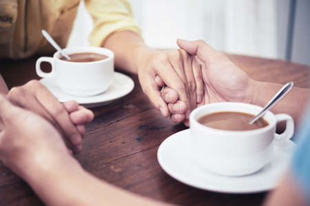 Hands of couple having date in cafeの写真素材