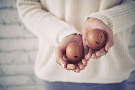 Woman showing eggs with smiles on themの写真素材