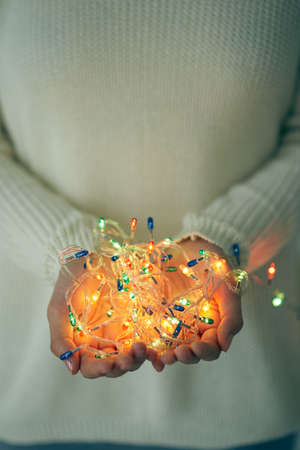 Female hands holding glowing lights: festivity and celebrationsの写真素材