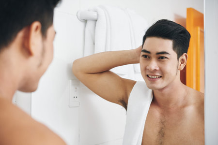 Handsome Vietnamese man getting ready in bathroomの写真素材