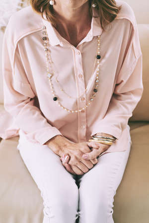 Cropped image of woman sitting on sofa , view from aboveの写真素材