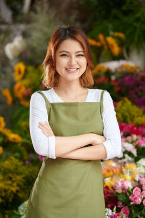 Pretty Asian girl standing in front of her flower shopの写真素材