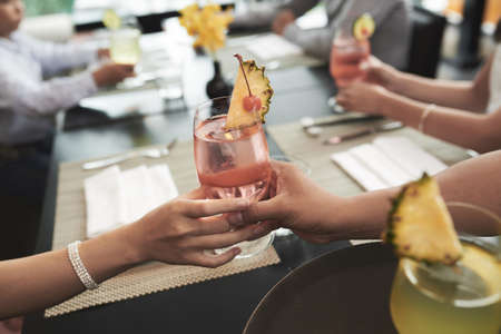 Close-up image of person giving cocktail at dinner tableの写真素材