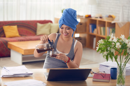Woman having cup of coffee after showerの写真素材