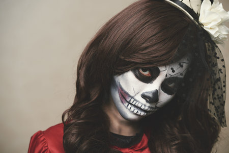 Woman with sugar skull make-up looking at camera
