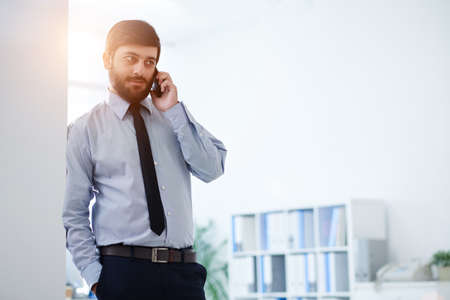 Businessman talking on the phone in his officeの写真素材
