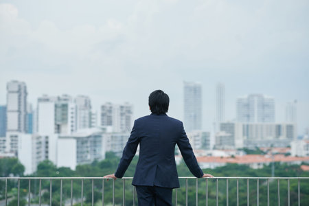 Rear view of businessman looking at the cityの写真素材