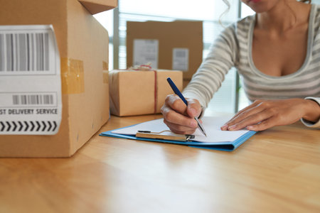 Woman writing down addresses for the parcels she is going to send