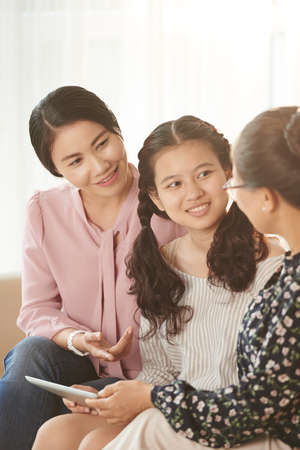 Female generation of Vietnamese family chatting at homeの写真素材