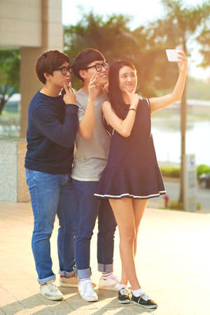 Korean teens making faces when taking selfie togetherの写真素材