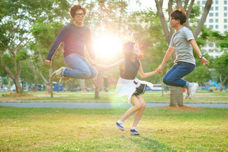 Korean teens having jumping and having fun in the parkの写真素材