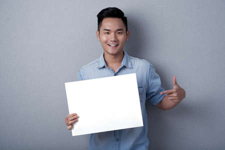 Smiling Asian Man with Sheet of Paperの写真素材